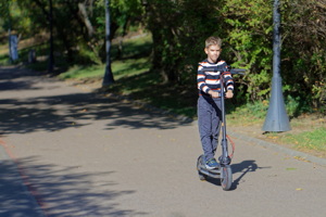 Little boy riding an electric scooter
